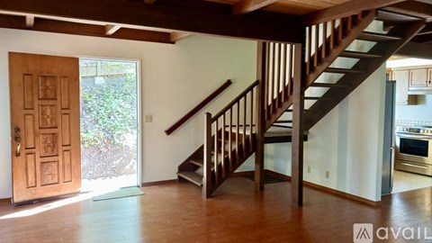 A wooden staircase with a railing leads up to a second floor.