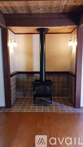 A wood stove is in a room with a tiled floor.
