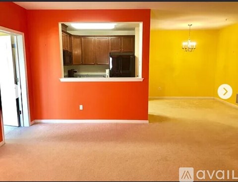 A room with orange walls and a small kitchen area.