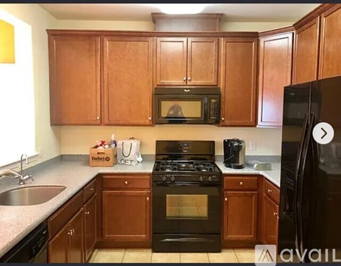 A kitchen with brown cabinets and black appliances.