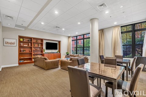 A spacious living room with a large table and chairs.