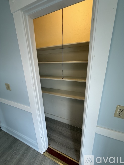 A bedroom with a bed, a window, and a door.