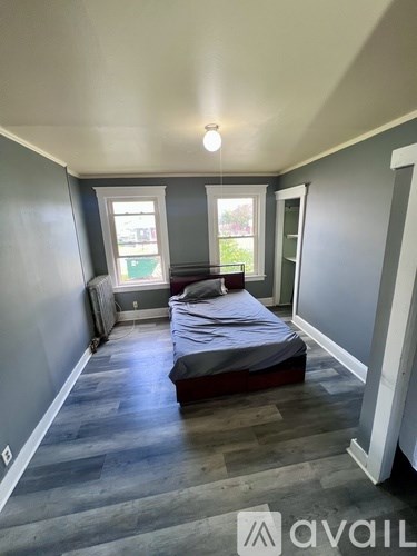 A bedroom with a bed, a window, and a door.