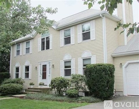 A two-story house with a white door and windows.