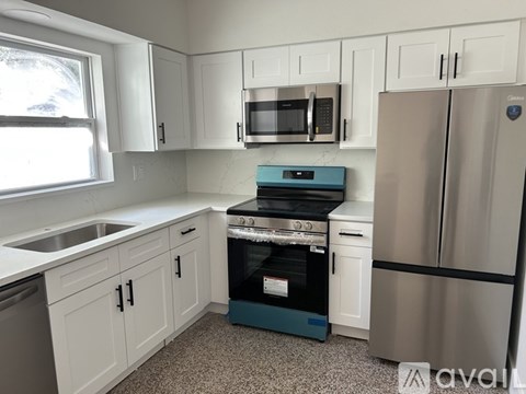 A kitchen with white cabinets and a blue oven.