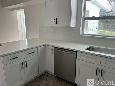 A kitchen with white cabinets and a dishwasher.