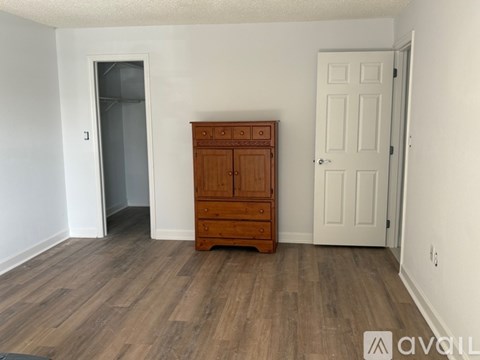 A room with a wooden dresser and a white door.
