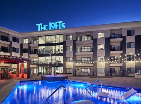 The IOFTS building is lit up at night with a pool in the foreground.