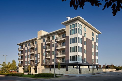 A large apartment building with a clear blue sky in the background.