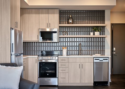 A modern kitchen with a stainless steel refrigerator and oven.