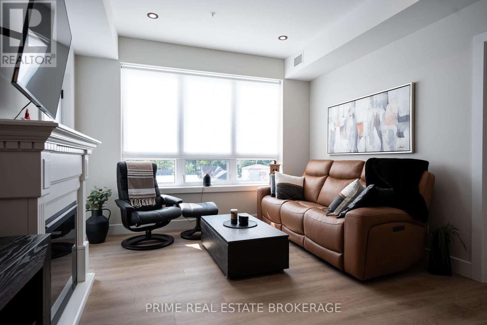 A living room with a brown leather couch and a black chair.