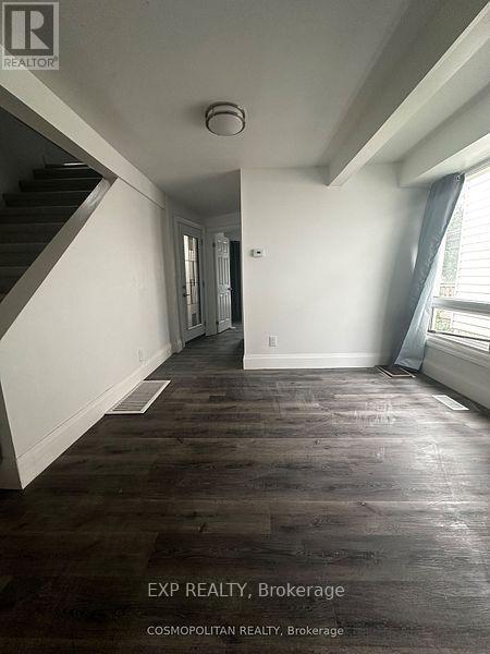 A room with wooden floors and a staircase.