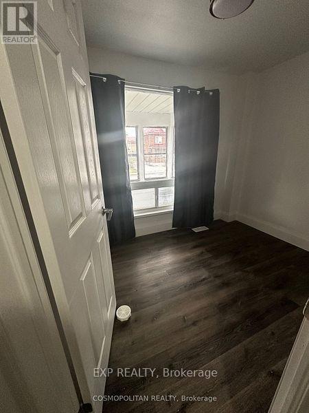A room with wood flooring and a sliding door leading to a balcony.