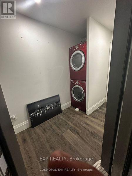 A room with a red speaker and a black picture on the wall.