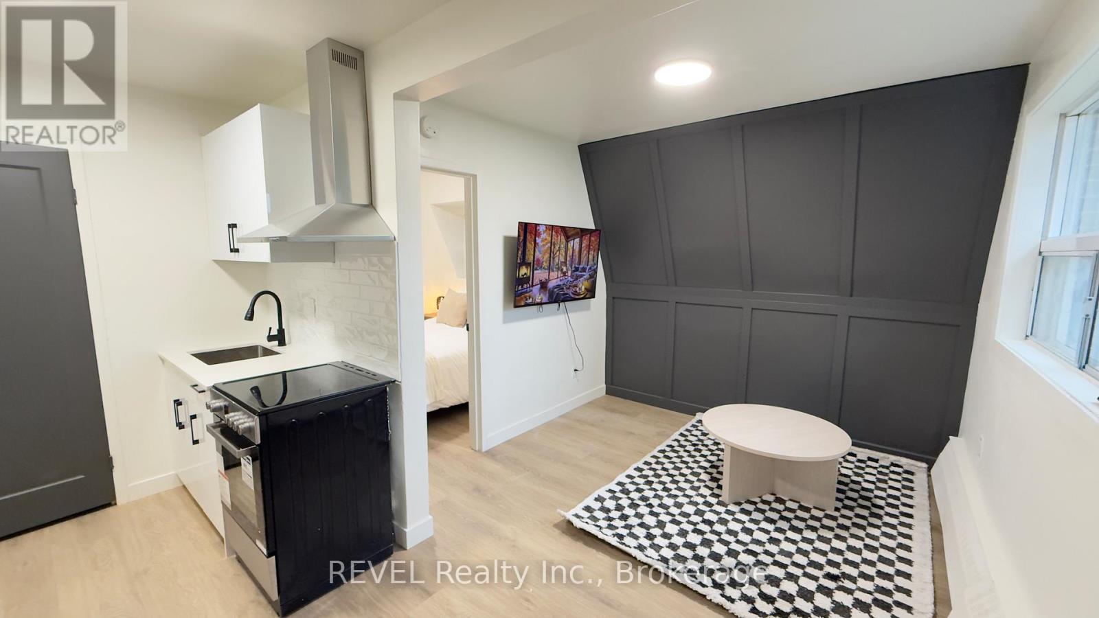 A modern kitchen with a black and white checkered floor mat.