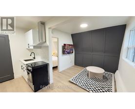 A modern kitchen with a black and white checkered floor mat.