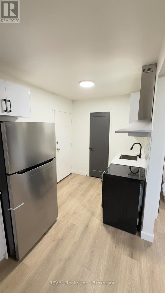 A kitchen with a stainless steel refrigerator and a black dishwasher.
