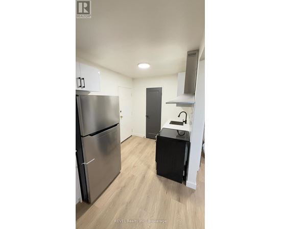 A kitchen with a stainless steel refrigerator and a black dishwasher.