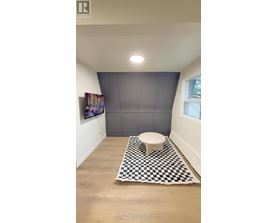 A bathroom with a toilet and a checkered rug.