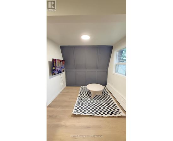 A bathroom with a toilet and a checkered rug.