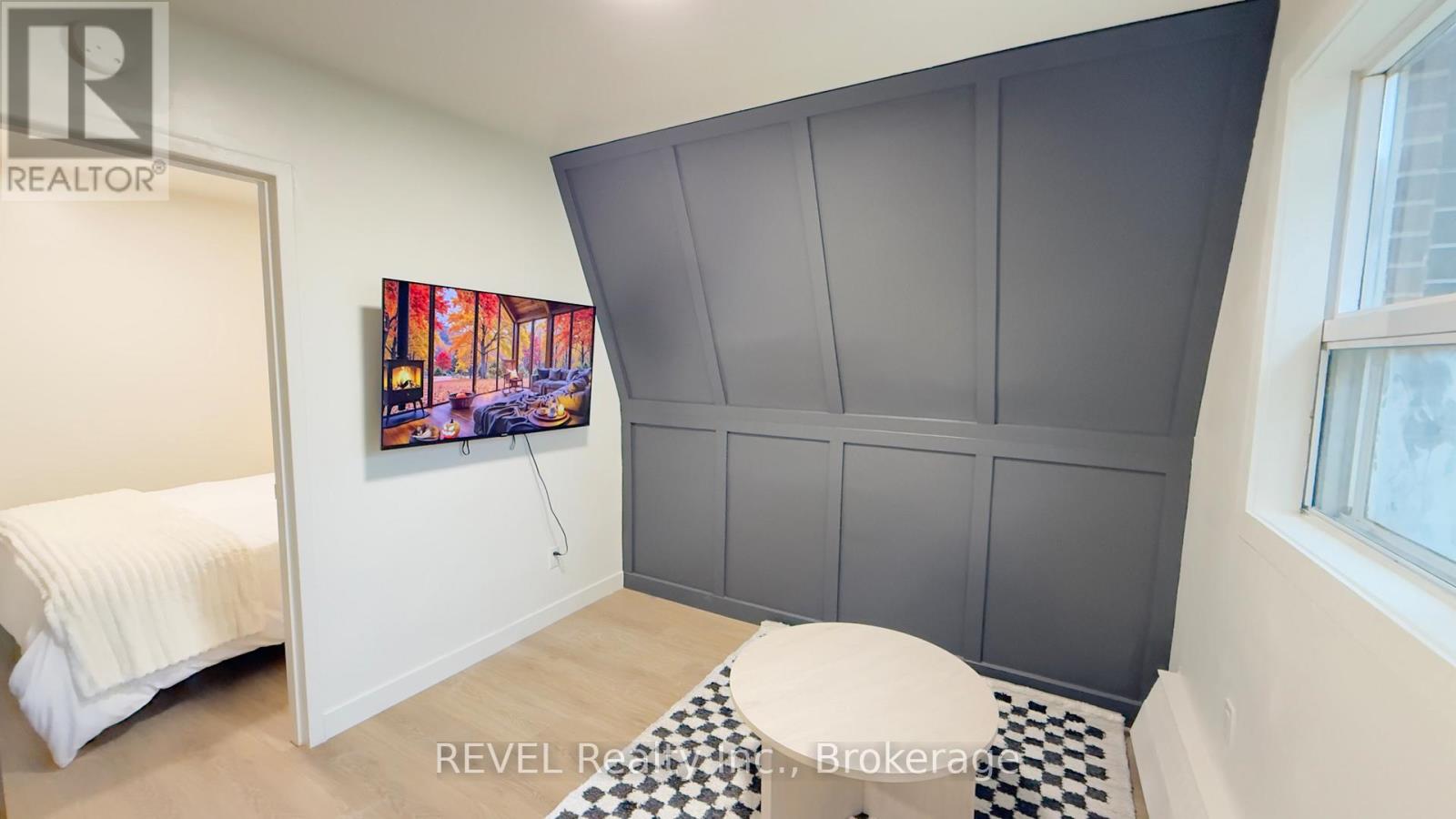 A bedroom with a bed, a painting, and a checkered floor.