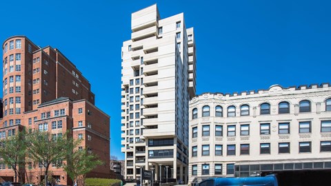 Exterior view of 929 Mass Apartments, a modern high-rise building surrounded by historic architecture in Cambridge MA.