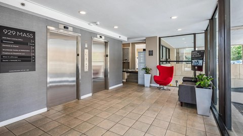 Lobby entrance at 929 Mass Apartments featuring elevators, seating, and resident mail area.