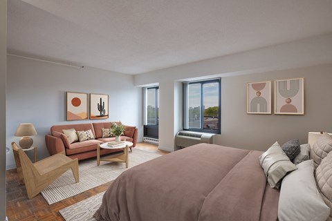 A bedroom with a large bed and a couch with pillows.