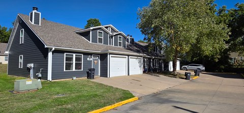 A two-story house with a garage and a driveway.