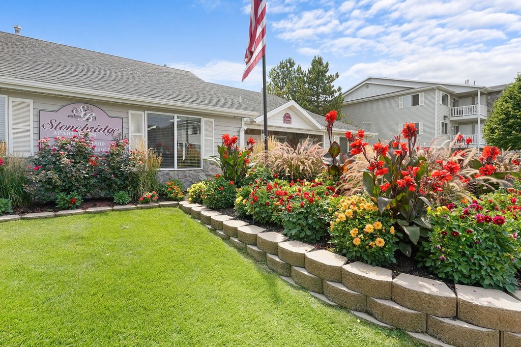 A garden in front of a house with a sign that says "The Stableberry".