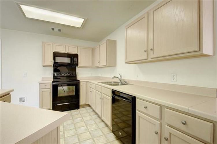 A kitchen with a black oven and white cabinets.
