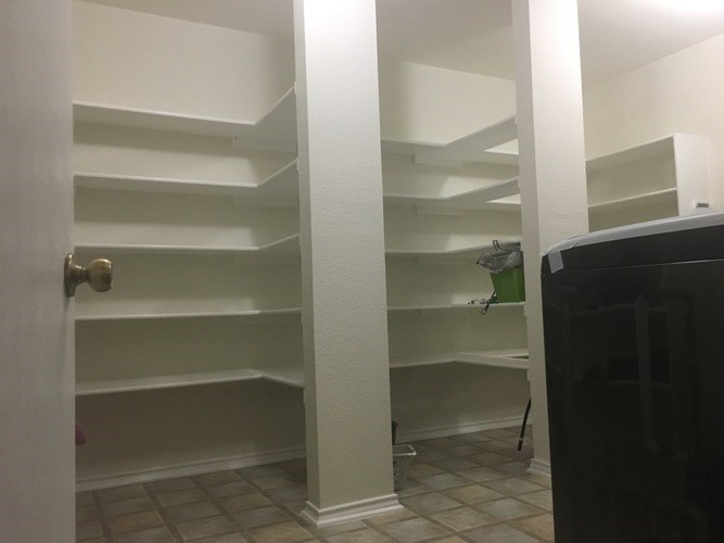 A white closet with a black dresser in the corner.