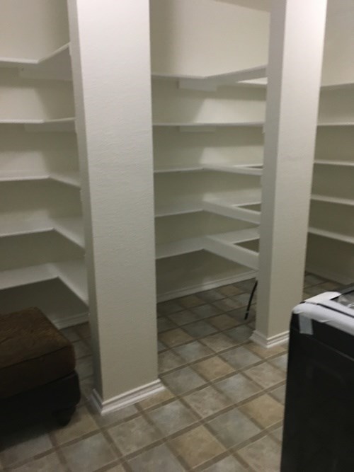 A white shelving unit with no shelves on the bottom row.