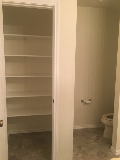 A white door is open to a bathroom with a toilet.