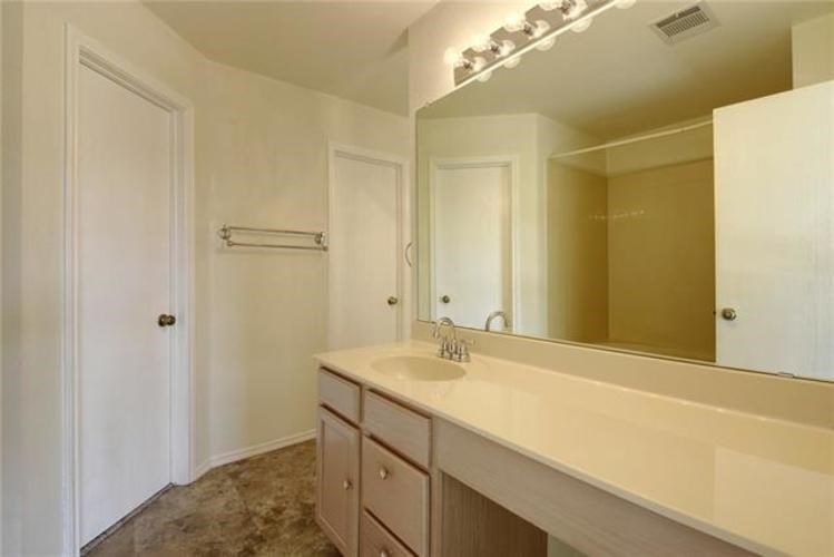 A bathroom with a sink, mirror, and cabinets.