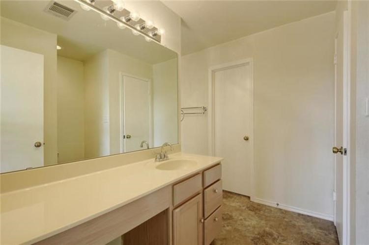 A bathroom with a vanity and a mirror.