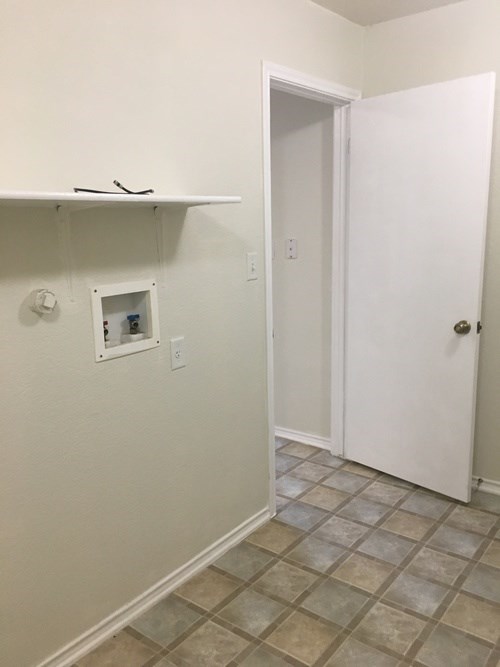 A white door is in a room with a tiled floor.