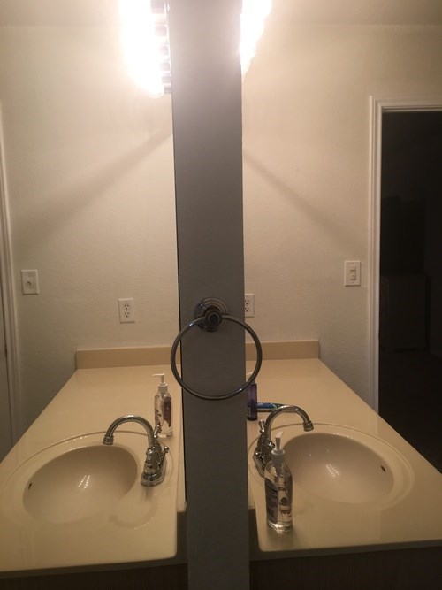 A bathroom with two sinks and a mirror.