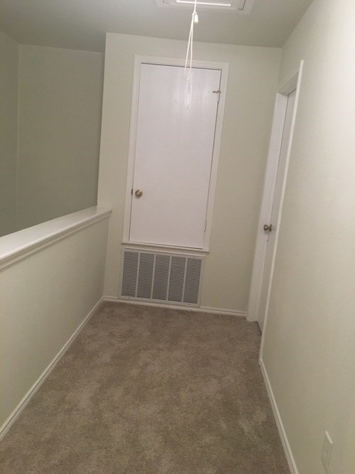 A white door is in a room with carpeting.