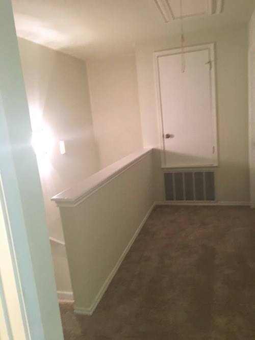 A room with a white door and a window on the left side.