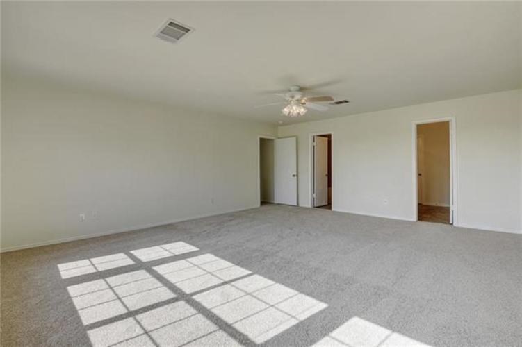 A room with a ceiling fan and carpeted floor.