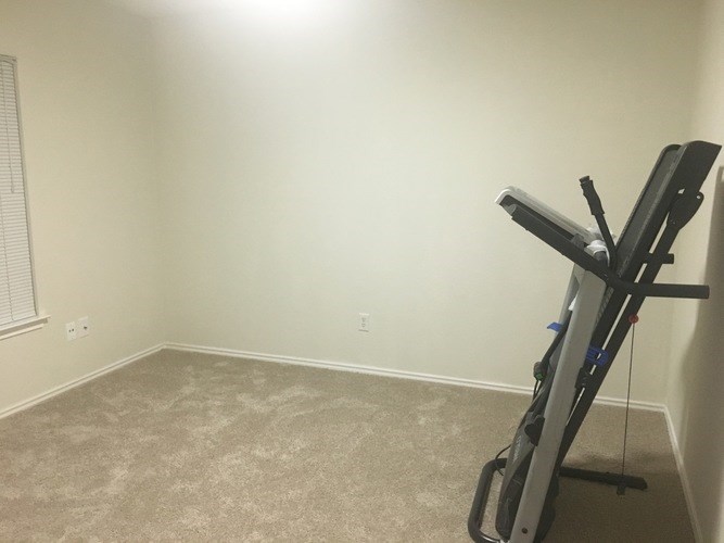 A room with a treadmill in it.
