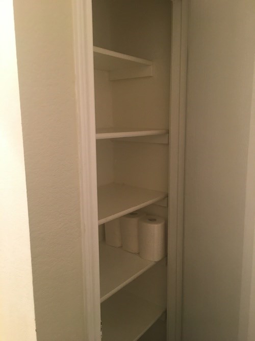 Empty white shelves in a pantry.