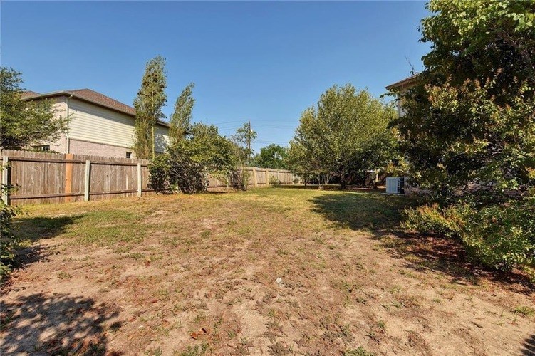 A backyard with a fence and trees.