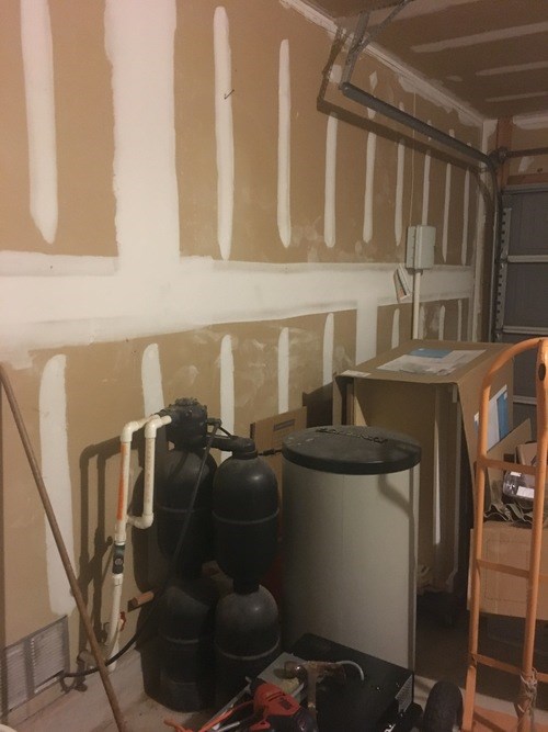 A room with a lot of pipes and a tank.