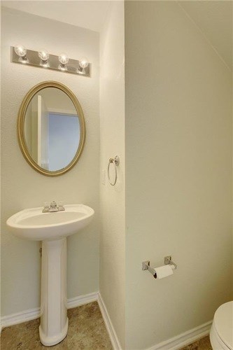A bathroom with a sink, mirror, and lights.