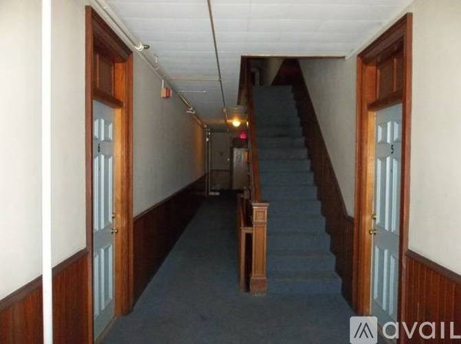 A staircase with a blue carpet and wooden steps.