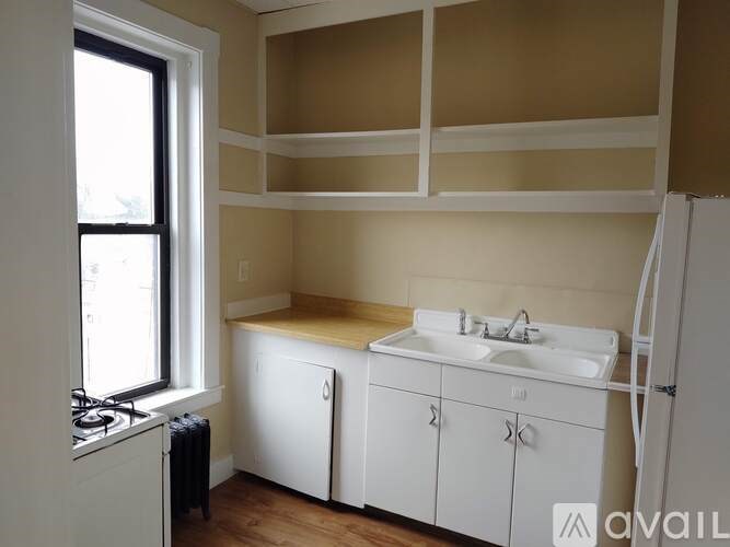 A kitchen with white cabinets and a window.