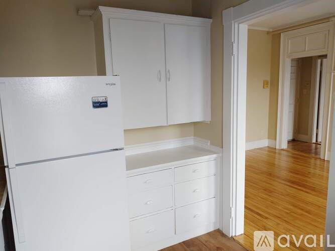A white fridge and cupboards in a kitchen.