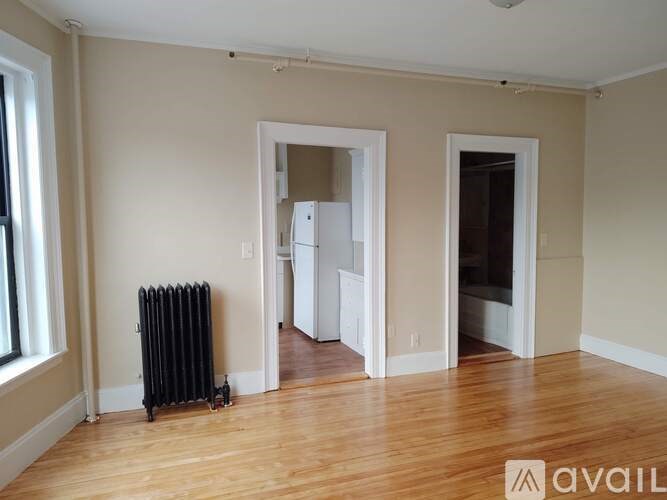 A room with a black radiator and wooden floors.
